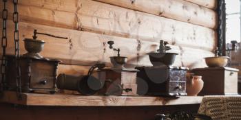 Vintage coffee mills stand in a row on wooden shelf