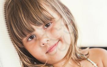 Slightly smiling Caucasian little girl, close up face portrait
