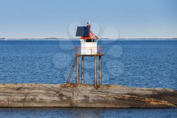 Traditional Norwegian steel lighthouse tower with solar battery and conical red top