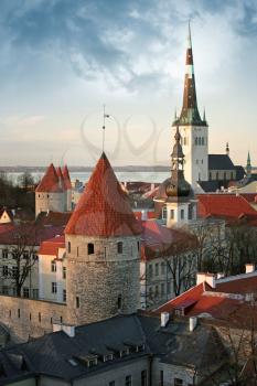 Old town of Tallinn. Houses, fortress towers with red roofs and church St. Olaf