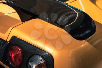 Luxury yellow sports car fragment, rear aerodynamics carbon spoiler and rear lights