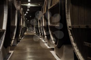 Vintage wooden barrels in winery basement, close up photo with selective focus