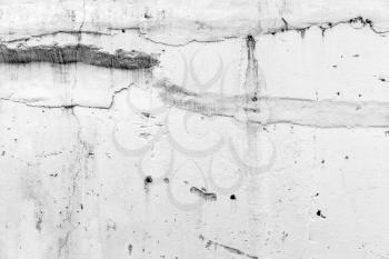 White concrete wall with damaged stucco layer, background photo texture