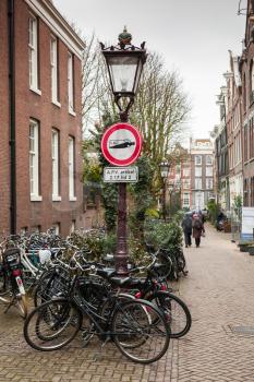 Alcohol prohibition sign mounted on vintage street lamp in Amsterdam, Netherlands. The sign prohibits drinking alcohol beverages on the street