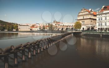 Old wooden dam on Vltava river. Prague in summer evening, Czech Republic. Vintage stylized photo with warm tonal filter effect