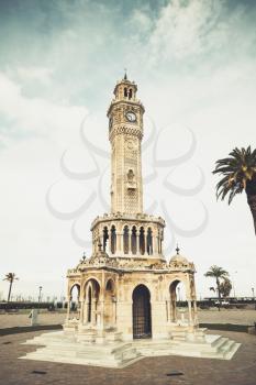 Historical clock tower on Konak Square. it was built in 1901 and accepted as the official symbol of Izmir City, Turkey/ Vintage toned vertical photo