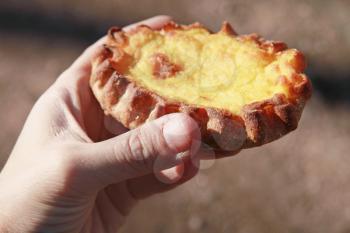 Traditional Karelian pie with rice filling in male hand, closeup photo with selective focus