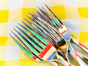 Set of forks with nice colorful reflection on a napkin