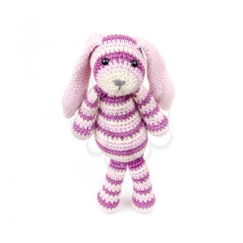 Sad knitted rabbit toy stands over white background with soft shadow