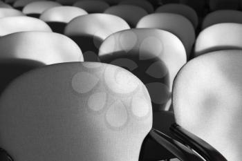 Gray armchairs in a rows, empty auditorium interior fragment