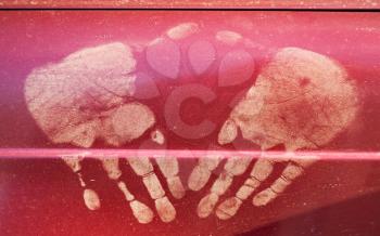 Dirty hand prints on red car door