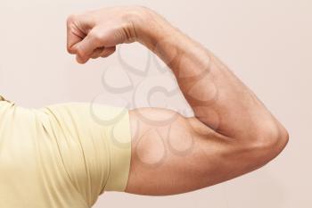 Strong male arm shows biceps. Closeup photo
