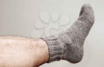 Closeup photo of male foot with gray woolen sock
