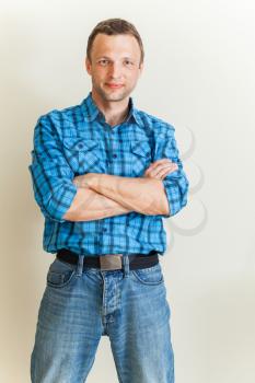 Studio portrait of young Caucasian man in blue checkered shirt