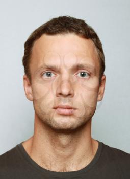 Young Caucasian man closeup portrait. Headshot on gray