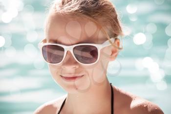Little blond girl with sunglasses, closeup portrait, vintage toned photo filter effect