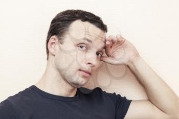 Young thinking Caucasian man, portrait over gray wall background