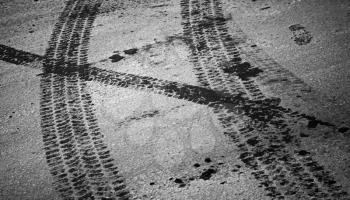 Tire tracks and footstep on the asphalt urban road