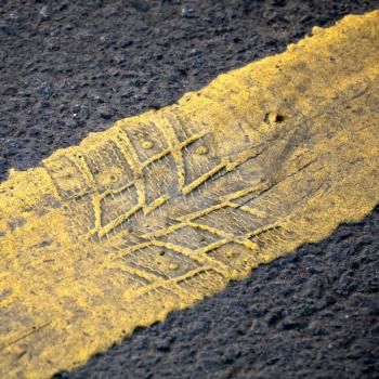 Abstract road background with yellow line and tire imprint on the asphalt
