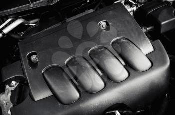 Modern car engine under black hood, black and white photo with selective focus