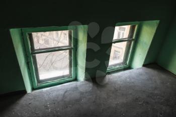 Two small windows in green wall, urban interior fragment