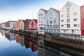Colorful old wooden houses stand along Nidelva river coast. Trondheim, Norway