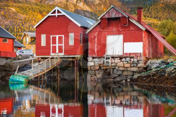 Traditional Norwegian red wooden fishing barns stand on the sea coast. Snillfjord, Sor-Trondelag region, Vingvagen fishing camp 
