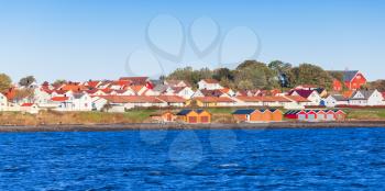 Colorful wooden houses stand on sea coast in Norway, Brekstad