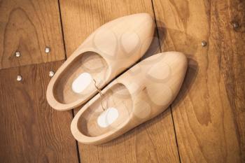 Pair of clogs made of poplar wood. Klompen, traditional Dutch shoes for everyday use stand on wooden floor, top view