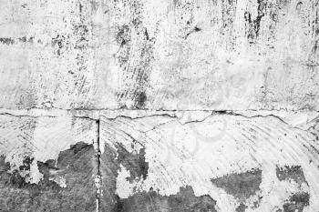 Old concrete wall with peeling white paint layer, background photo texture