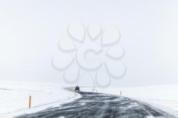 Turning Icelandic road covered with snow, empty winter landscape