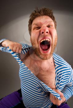 Angry prisoner bandit tearing clothing on himself