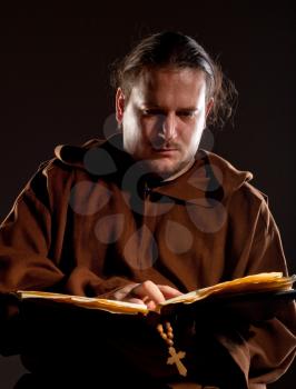 Portrait of pensive monk reading the bible