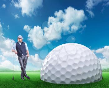 Confident businessman stands near a huge golf ball