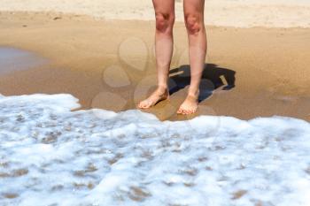 Up view of female bare feet on the coastline
