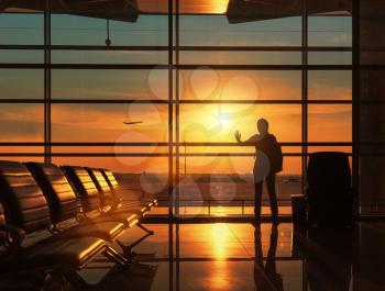 Silhouette of traveling woman waiting for the flight in airport at sunset