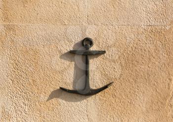 Black anchor on the stone wall 