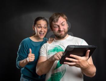 Couple with tablet having fun