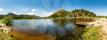 Wooden pier on lake against pine forest mountain panorama at Rocky Mountain National Park USA