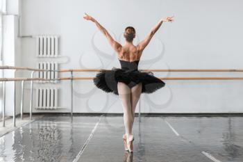  Graceful ballerina dance in ballet class, barrre and white wall on background