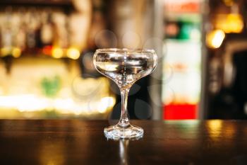 Transparent beverage in glass on wooden bar counter