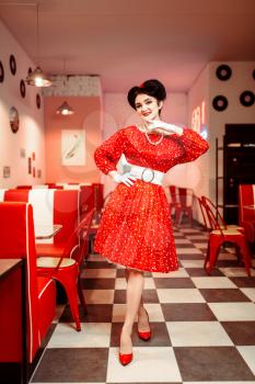 Pin up woman in red dress with white dots, vintage style. Retro cafe interior with checkerboard  floor
