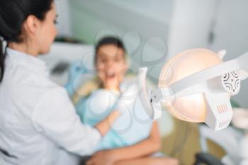 Boy in clinic, dental care, pediatric dentistry. Female dentist examines the teeth of a small patient