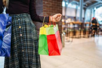 Female person with shopping bags in mall. Shopaholic in clothing store, consumerism lifestyle, fashion, woman purchasing in shop