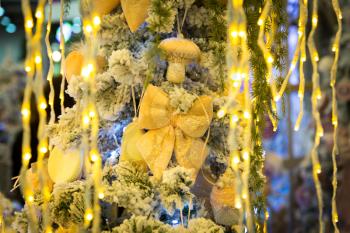 Christmas tree with yellow decor and lights, garland closeup. Xmas decoration, new year. Winter holiday celebration