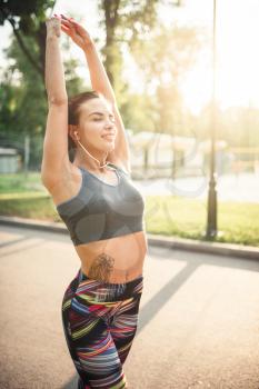 Athletic girl on morning fitness training in summer park. Slim woman in sportswear, outdoor fit workout