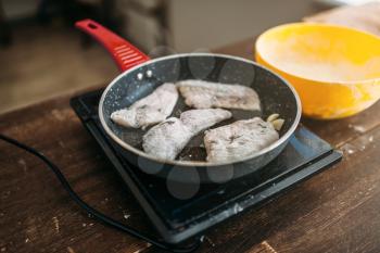 Frying pan with fish slices, seafood cooking. Sea bass fillet