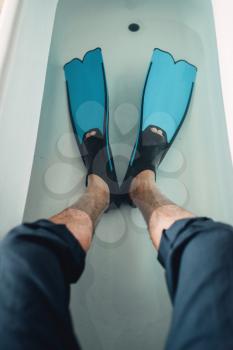 Funny businessman in flippers sitting on the edge of the bathtub, humor. Business fortune concept