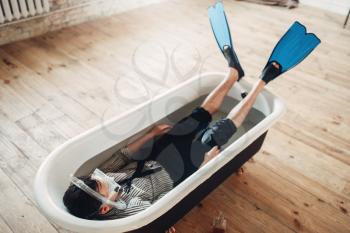 Funny businessman in flippers and mask lies in bathtub, humor. Business lottery concept