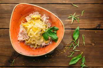 Pasta and meat in a bowl on wooden table closeup, nobody. Second dish, food preparation, cooking